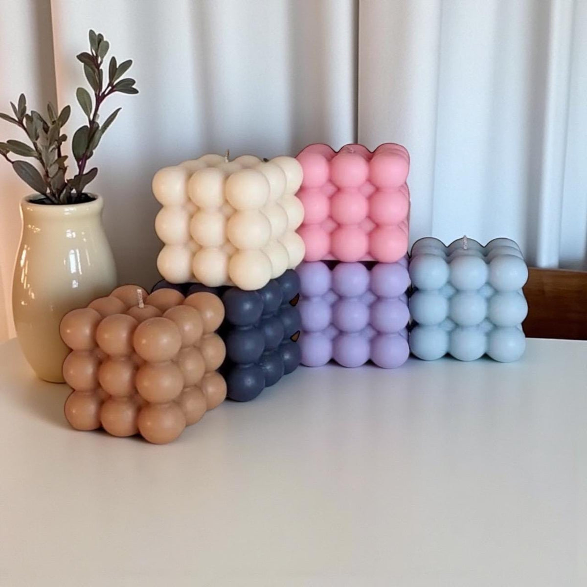 Handmade bubble cube candles in neutral and pastel colors displayed as modern home décor